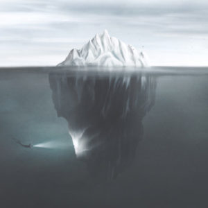 Taucher mit Fackel, der die untere Seite des Eisbergs unter Wasser beleuchtet.